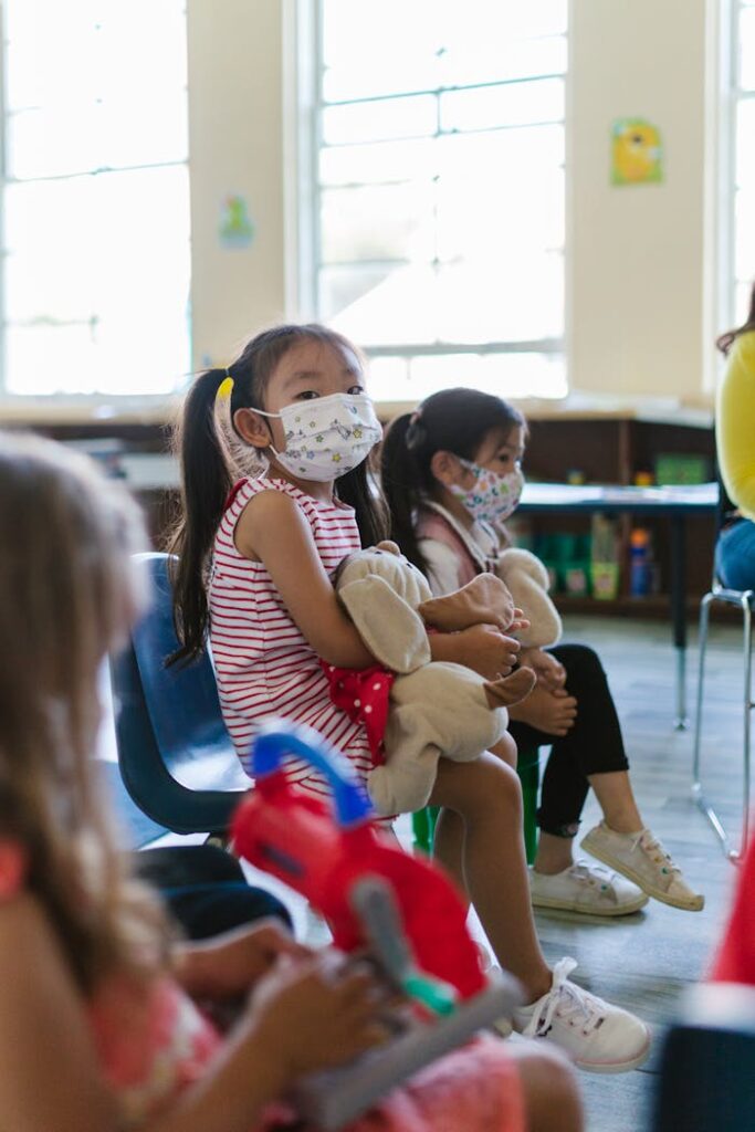 Children in a classroom wearing face masks, attending school during pandemic.